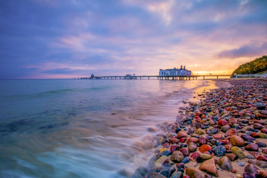 Sonnenuntergang an der Ostseeküste mit Seebrücke und Steinstrand